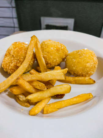 French fries are delicious placed on a white plate and suitable for healthy snacksの写真素材