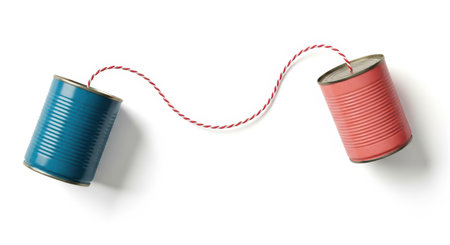 Creative communication concept with tin cans connected by red twine on white background.の素材