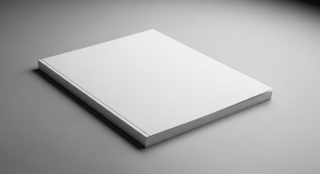 Minimalist blank book on gray surface with soft lighting.の素材