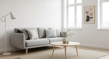 Minimalist living room with gray sofa and modern decor in bright natural light.の素材