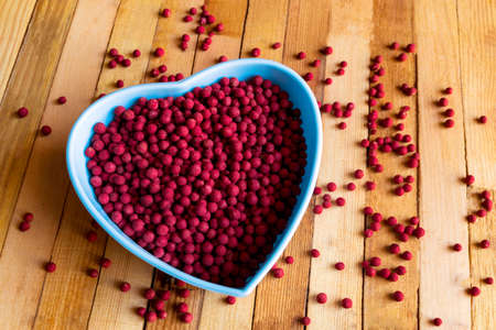 blue bowl full of red pepper on wooden background.の写真素材