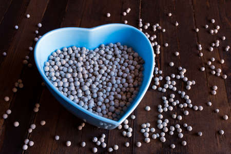 bowl full of white peppercorns on rustic wooden background.の写真素材