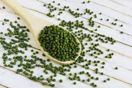 Top view of dry green pepper corns  in white spoon.の写真素材