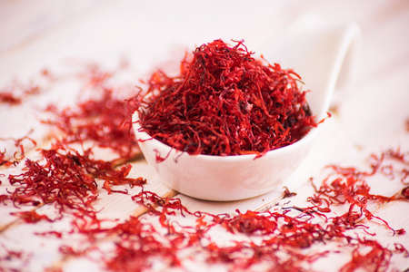 Closeup of spoon full of dried red saffron.の写真素材