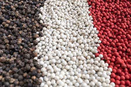 three peppercorns background. black, white and red peppercorns.