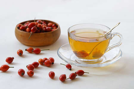 Rose hip herb and rose hip herbal tea in cup on white background.の写真素材