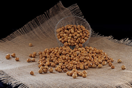 yellow spices pouring from glass jarの写真素材