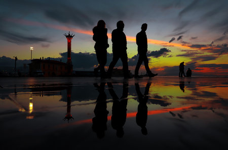 People walking around in Turkey -Izmir - Cumhuriyet square at sunset, silhouettes, reflect.の写真素材