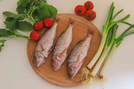 Raw kidney beans on wood , vegetables in background, herbs, b. Tabby fish getting ready to cook....