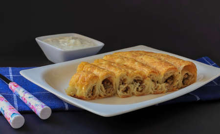 Turkish pastry with minced meat on a white plate. A traditional Turkish pastry, roll pastry. Its local name is Bosnian pastry.の写真素材