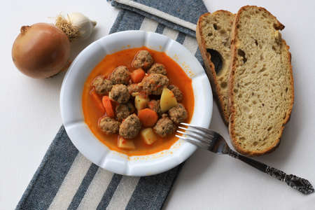 Sour Meatballs with Potatoes and Carrots in a White Plateの写真素材