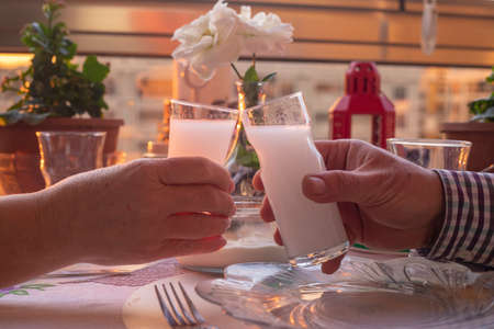 Beautiful Couple Sitting, Drinking, Cheers and Drinking Turkish Traditional Drink Raki, Ouzoの写真素材