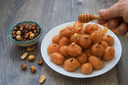 A bowl of Lokma (Turkish), loukoumades (Greeek ) with other names in other languages, are pastries made of leavened and deep fried dough, soaked in syrup or honey, sometimes coated with cinnamonの写真素材