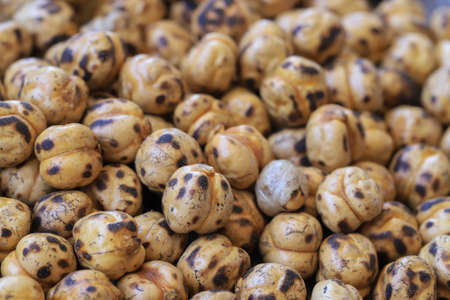 Roasted spicy chickpeas , yellow chickpeas on wooden background .の写真素材