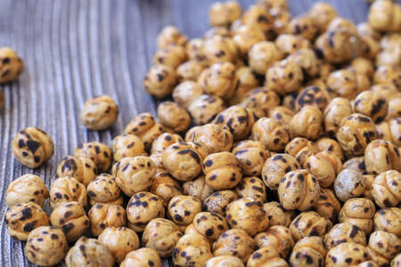 Roasted spicy chickpeas , yellow chickpeas on wooden background .の写真素材