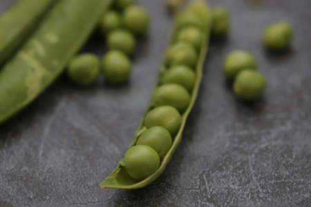 Fresh green peas isolated on black background.