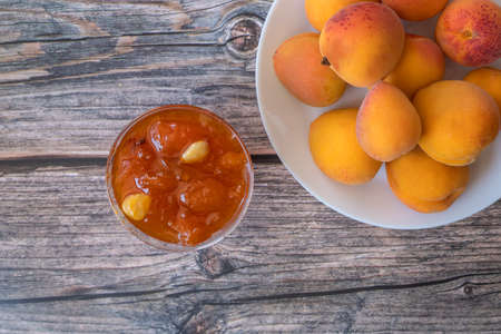 Apricots on the table and apricot jam in a glass bowl.の写真素材