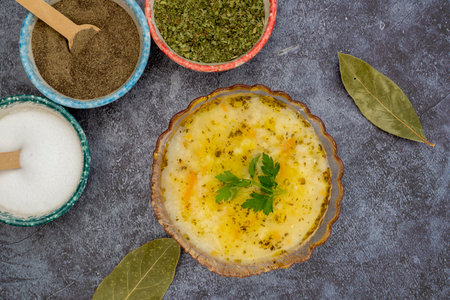 Chicken soup with vegetables and barley noodles in a glass bowlの写真素材