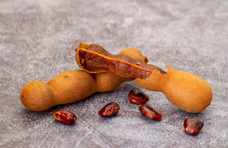 Close-up shot of tamarind fruits and seeds isolated on marble background.の写真素材