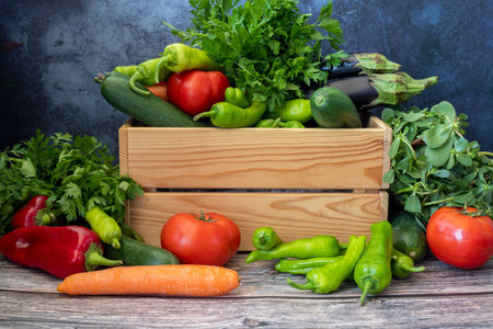 Various vegetables on a wooden table. Tomato, Green Pepper, Red Pepper, Parsley, Carrot, Eggplant, Cucumber.の写真素材
