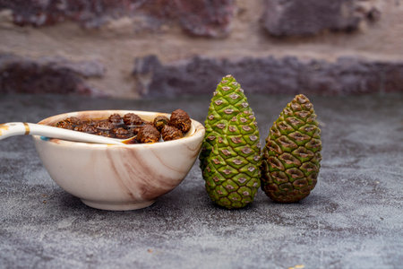 Young pine cones jam , molasses in glass bowl on gray marble background . Delicious jam with small pine cones, molasses.の写真素材