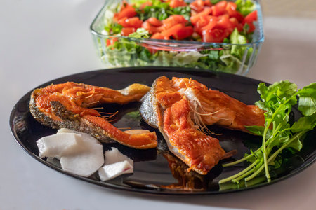 Fried mullet fish, greens and saladの写真素材