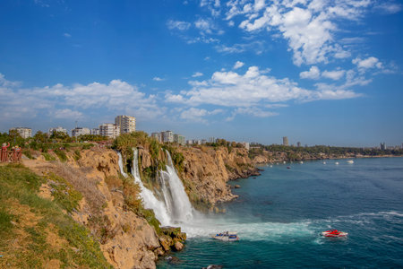 The moment when the Lower DÃ¼den waterfall flows into the sea, against the background of the steep shores of the Mediterranean and the urban development of the city.の写真素材