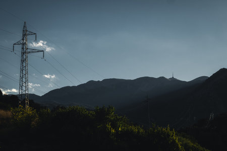 Beautiful landscape with electric pole and trees in the foreground with TV tower on top of the mountain in the background.の写真素材