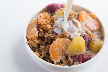 granola with ftuits salad on the white background.の写真素材