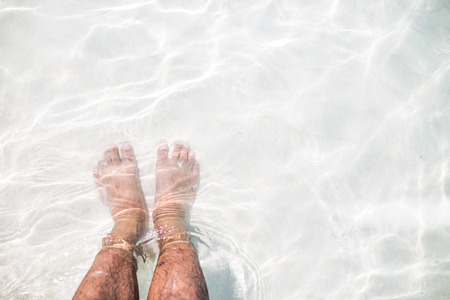 Foots on the white sand in the sea.の写真素材