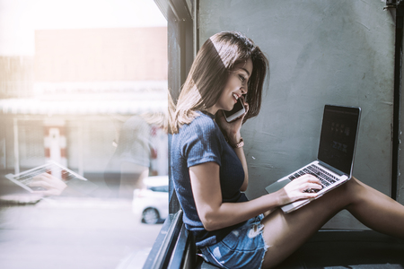 A women calling and use notebook in cafe coffee. working concept.の写真素材