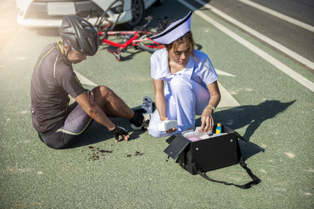 Injured man receiving first aid in the bike road.の写真素材