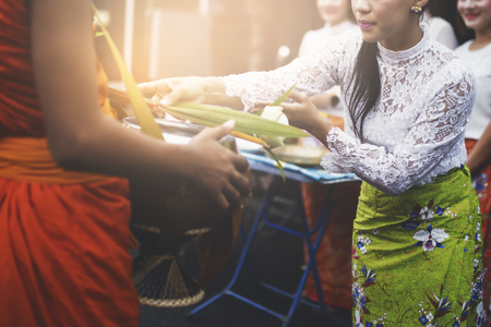 Thai woman give alms to a Buddhist monk in morning.の写真素材