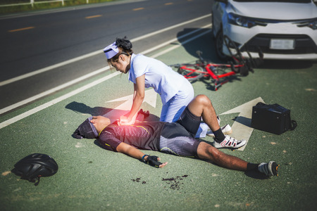 Female nurse helping Emergency CRP on bicycle man in an accidentの写真素材