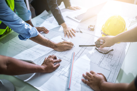 Image of engineer meeting for architectural project.  Young male and female architect colleagues drawing graphic planning of interior creation project cooperating with talented teacher giving advice and correcting mistakes during training lesson, working の写真素材