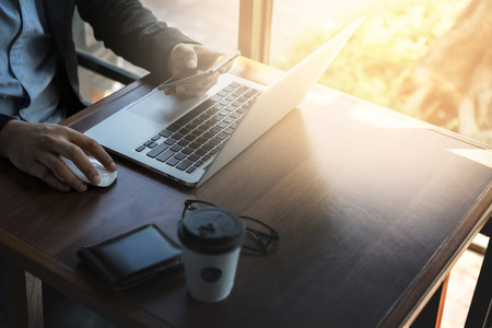 Business man working at coffee shop wiht laptop and smartphone.の写真素材