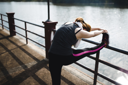 Close up of legs and torso of women. Young woman doing warming up before the morning run.