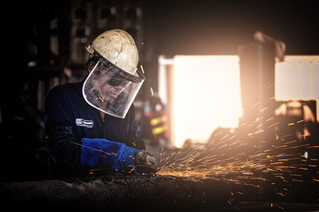 Electric wheel grinding on steel structure in factory.Handyman with electric grinder, grinding steel...