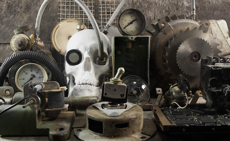 Mechanical skull and parts.White human skull with mechanical steampunk style metal parts composition on wooden table front view.の写真素材