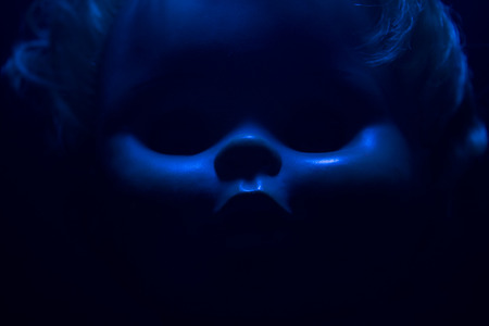 Horror doll face. Creepy horror photo of a fashioned doll face close up with black background.の写真素材
