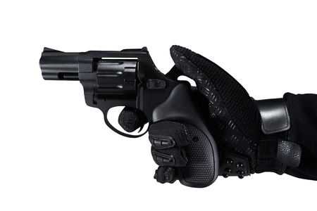 Hand in tactical black gloves holding a revolver black gun profile view.の写真素材