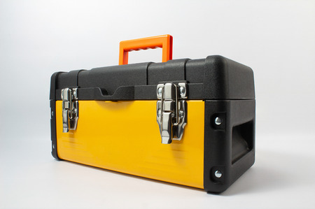 Yellow toolbox with orange arm grip standing on white background angle view.の写真素材