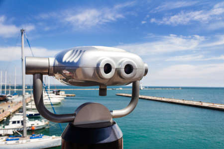 Coin operated binocular viewing machine on sea yacht port.
