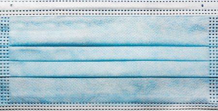 Close-up photo of blue medical face mask texture.