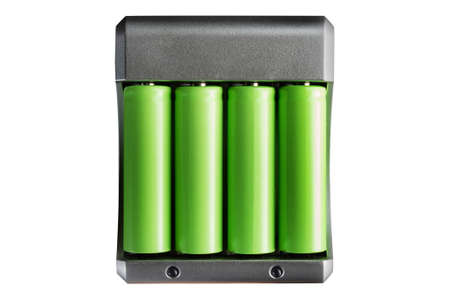Isolated photo of green colored lithium accumulator batteries in charger on white background.の写真素材