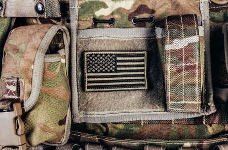 Close-up photo of multi camouflaged soldier vest pouches system with american flag patch..の写真素材