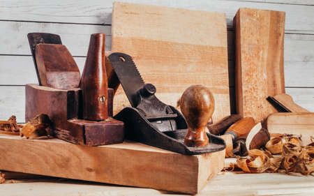 wooden old fashioned planes with laying on workbench table with sawdust.の写真素材