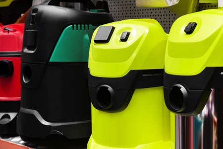 various industrial vacuum cleaners standing on construction supply store shelf.