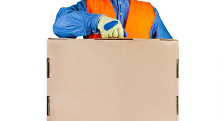 Isolated photo of loader worker in signal vest and protective gloves holding cardboard box with...