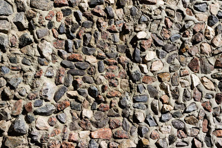 Texture photo of old small sized stone and concrete wall backdrop.
